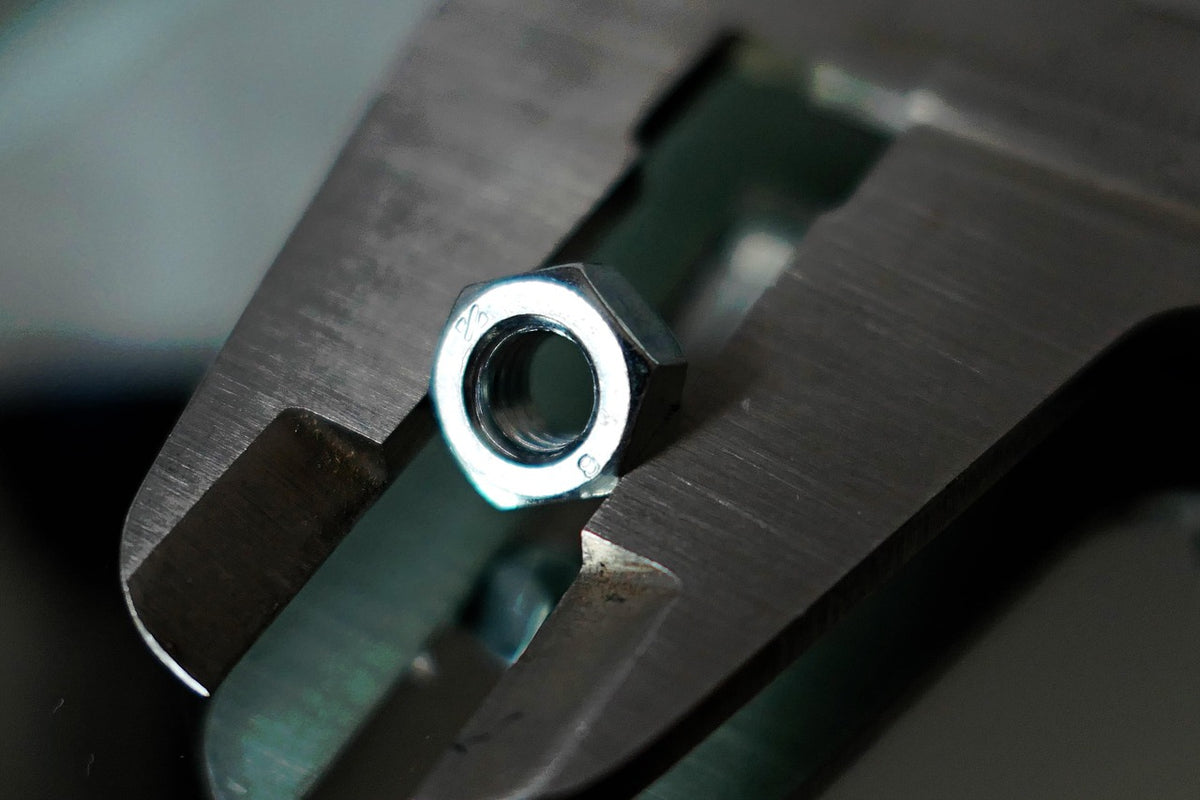 Caliper measuring a steel part, close-up
